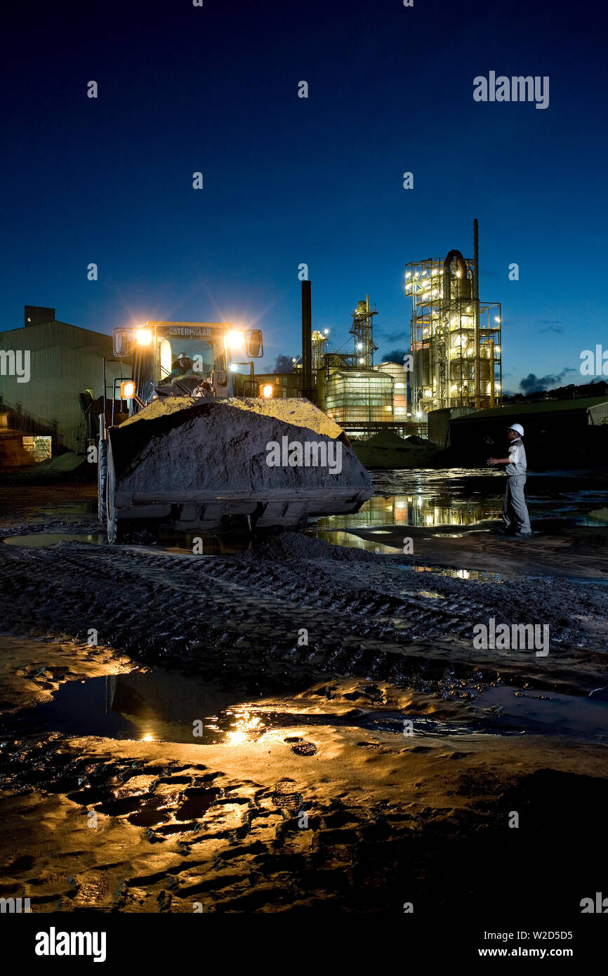 Estrazione, gestione e trasporto di sabbie minerali di titanio. Caricatore frontale che sposta il concentrato di sabbia minerale pesante dal cumulo di stock all'impianto di separazione. Foto Stock
