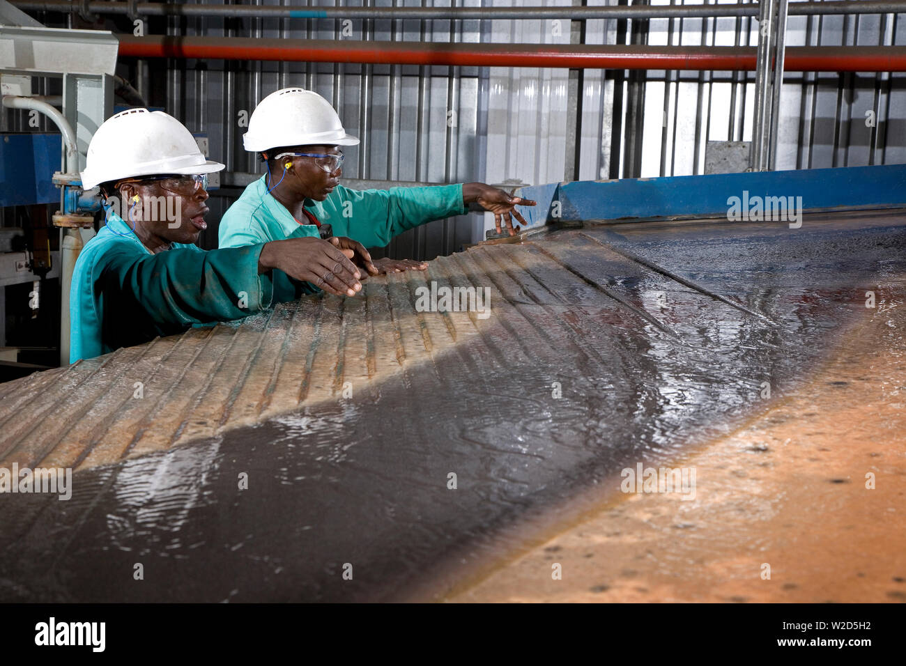 Miniere di titanio sabbie minerali. Impianto di separazione dei materiali. Operatori metallurgici che lavorano su tavoli di vibrazione o scuotimento Wilfley a gravità umida. Foto Stock