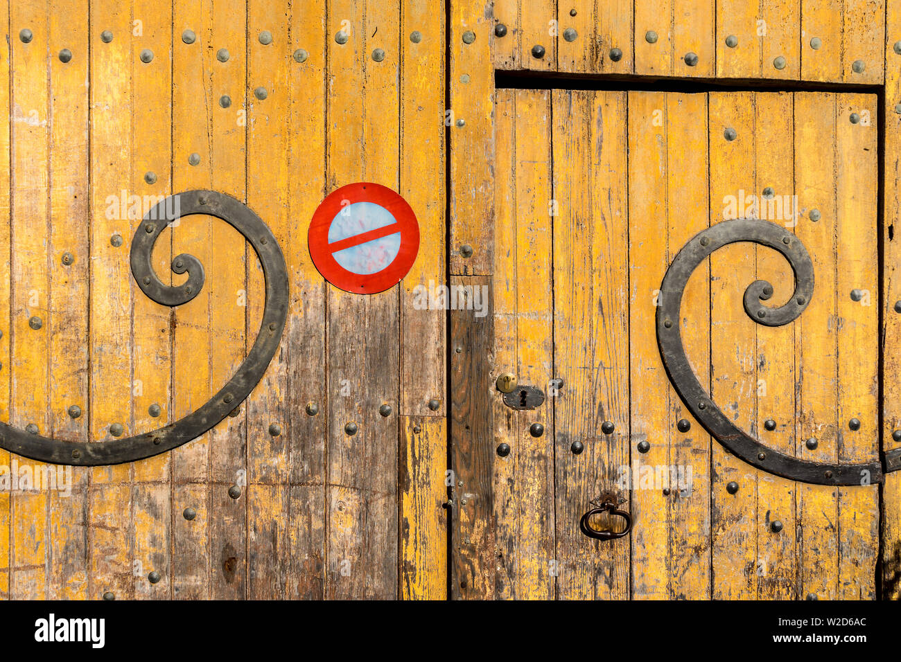 Vecchio ferro curvo delle cerniere sulla porta del garage - Francia. Foto Stock