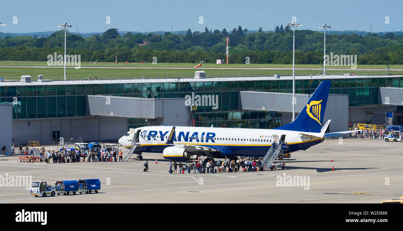 Voli Ryan Air lo scarico e il carico dei passeggeri all'Aeroporto di Stansted, Essex, Inghilterra sud-orientale, REGNO UNITO Foto Stock