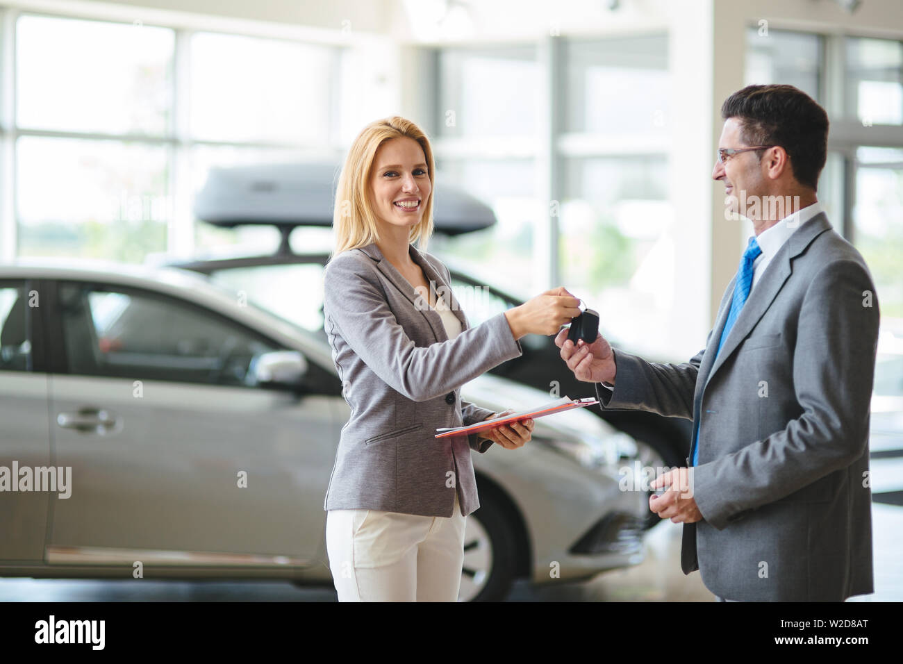 Giovani femmine auto consulente di vendita lavorando in showroom Foto Stock