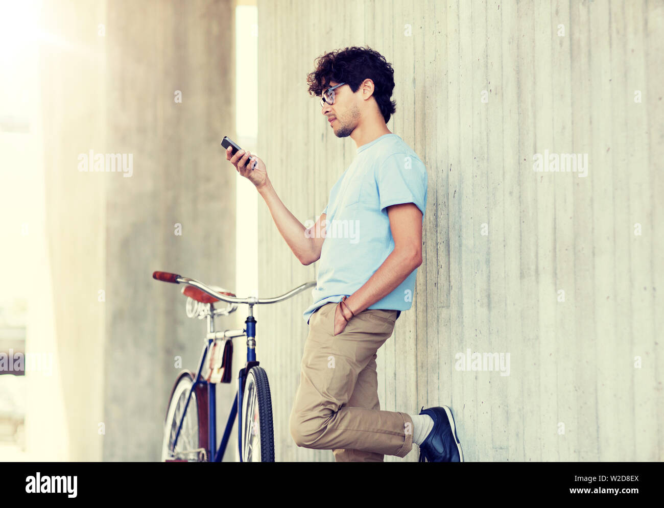 Uomo con lo smartphone e fixed gear bike su strada Foto Stock