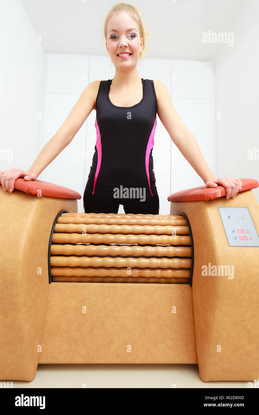 Dermocosmesi, bodycare, il concetto di benessere. Donna di liberarsi di cosce cellulite su grande rotolo macchina. Massaggio sani di trattamento in spa Foto Stock