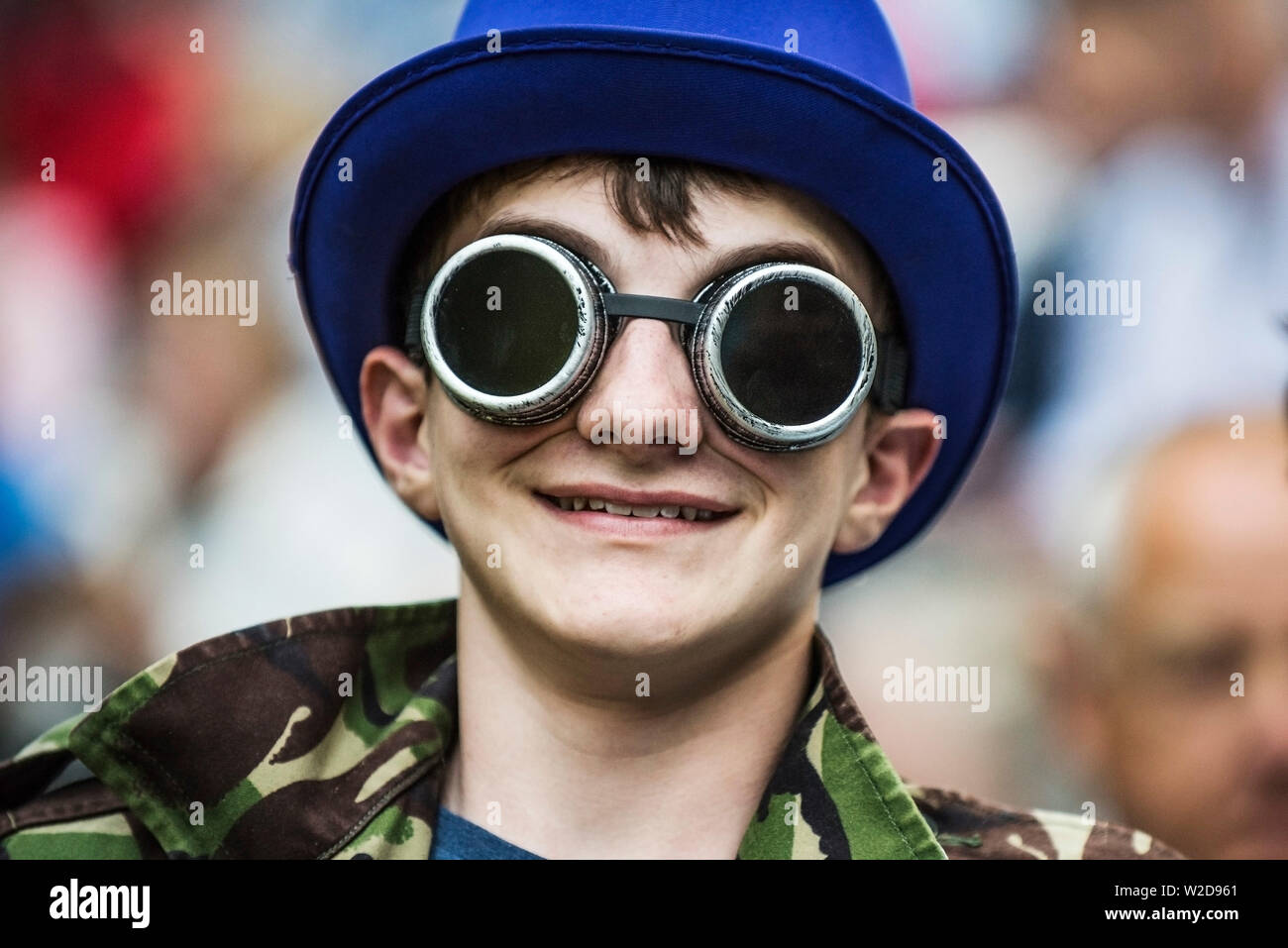 Un ragazzo adolescente che indossa gli occhiali di steampunk e un blu top hat. Foto Stock