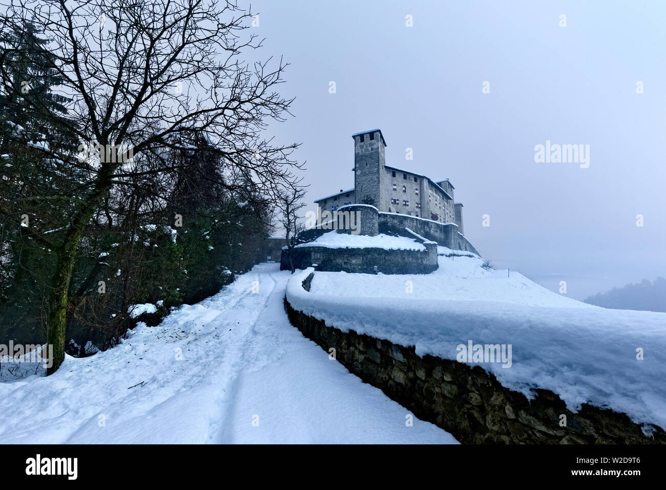La coperta di neve strada per il castello di Cles. Val di Non, in provincia di Trento, Trentino Alto Adige, Italia, Europa. Foto Stock