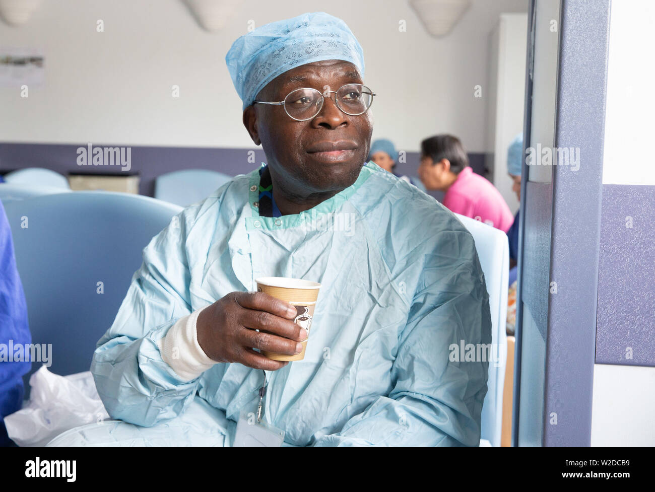 Un anestesista gode di una tazza di tè durante una pausa in un ospedale di NHS Foto Stock