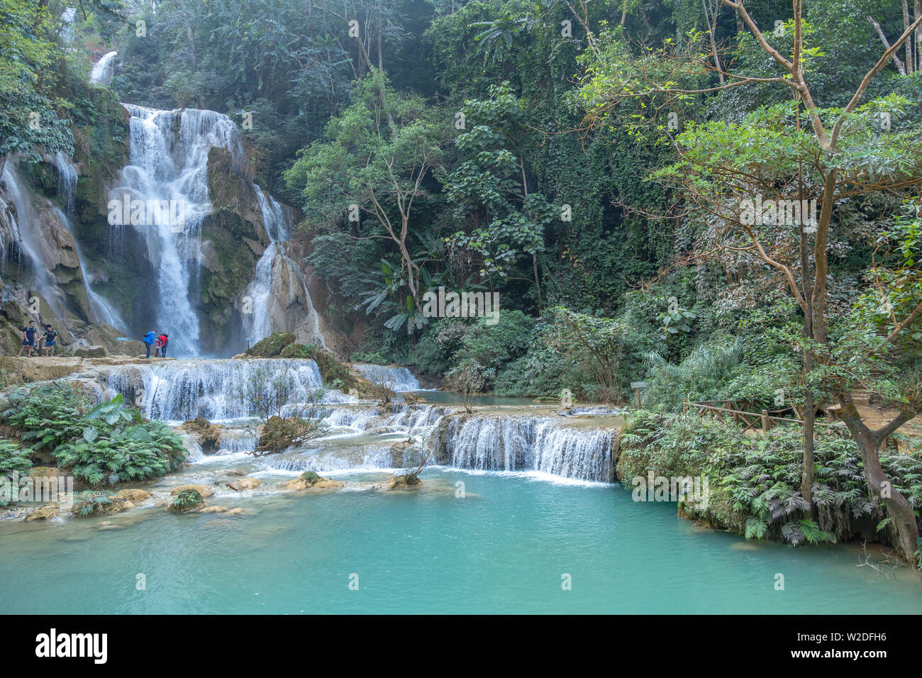 Luang Prabang, Laos - Dicembre 21, 2013: Cascata nella foresta di pioggia (Tat Kuang Si cascate a Luang Prabang, Laos.) con turisti nuoto Foto Stock