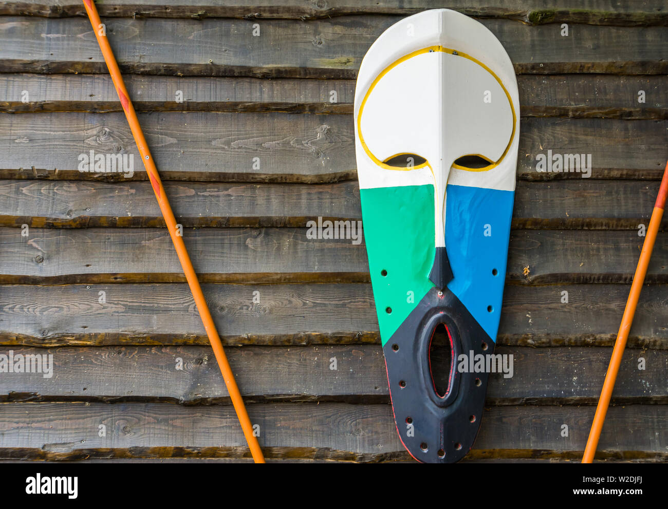 Africana tradizionale maschera di legno appeso a una parete in legno, cultura africana sfondo Foto Stock