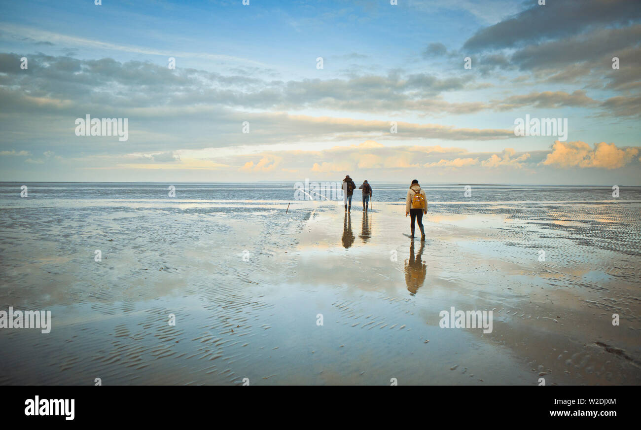 Gli escursionisti andando al Hermelles banchi di sabbia fuori la città di Cherrueix (Bretagna, a nord-ovest della Francia), nella baia di Le Mont Saint Michel (St. Michael's Foto Stock