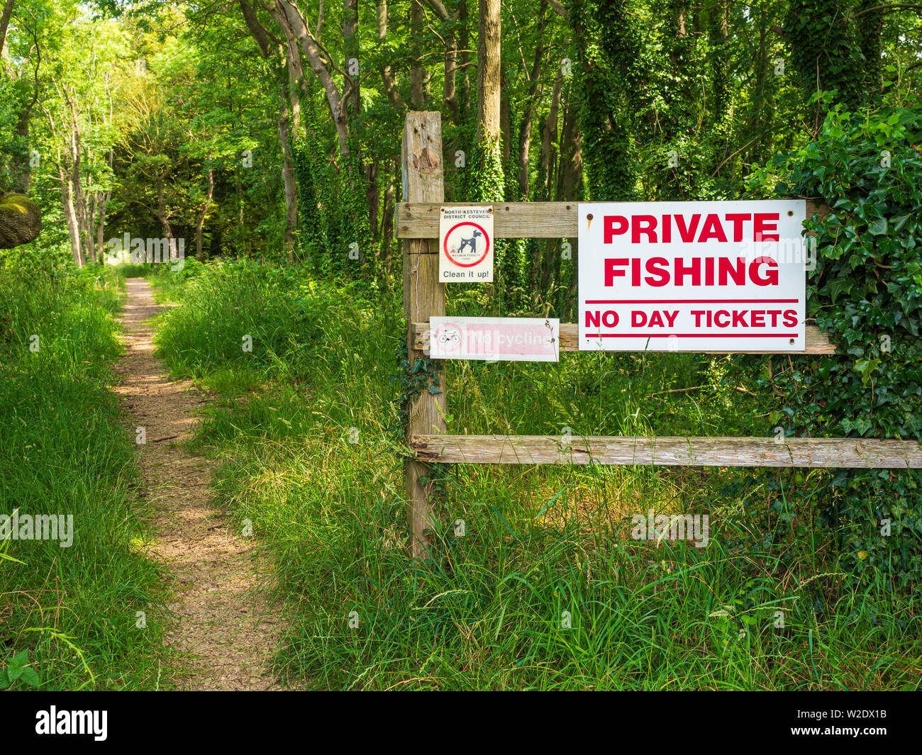 Biglietti privati per la pesca senza giorno e senza cartello con scritto cane Su una recinzione da un sentiero pubblico al Lago di Culverthorpe Nel Lincolnshire Foto Stock