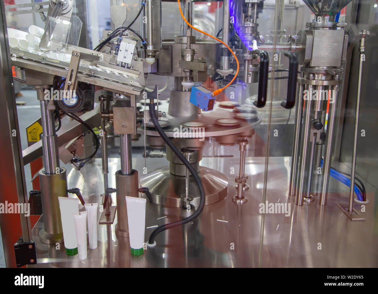 Il processo automatico di tubi cosmetici riempitrice e sigillatrice Foto Stock