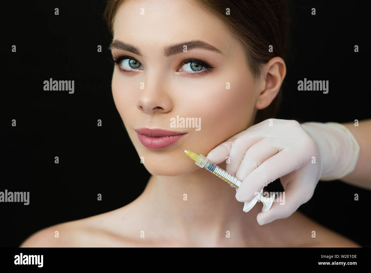 Bella donna di ottenere l'iniezione nella sua bocca per labbro augmentation. Procedura di labbri rendono più grande Foto Stock