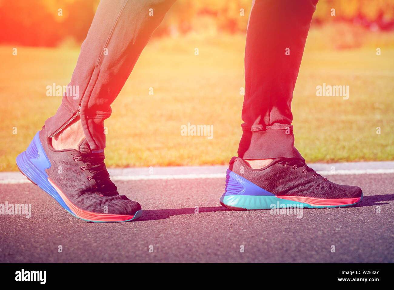 Runner atleta gambe di marcia su strada. La luce del tramonto Foto Stock