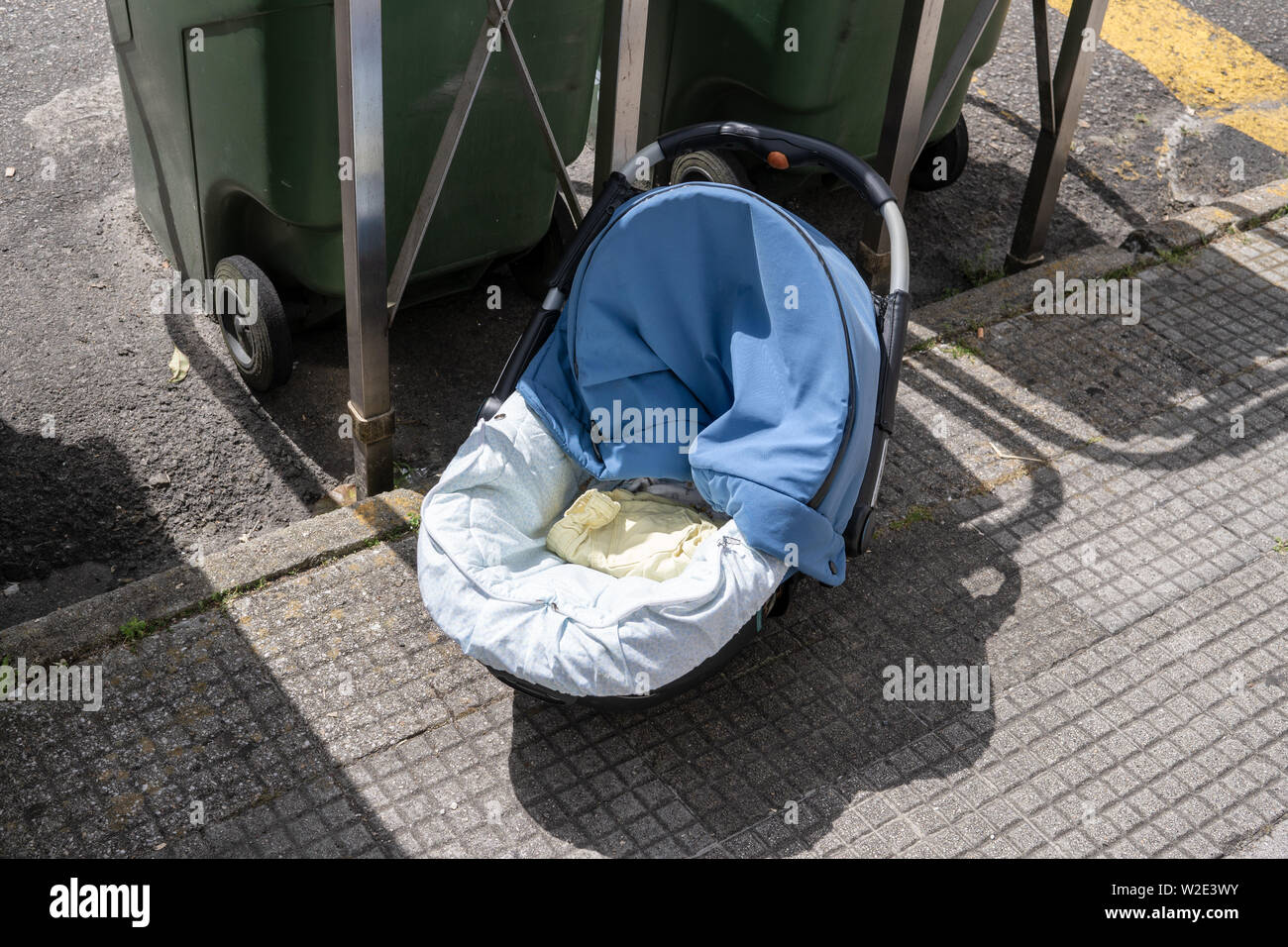 Bambino abbandonato il trasporto pubblico vicino cestino sul marciapiede. Concetto abbandonati Foto Stock