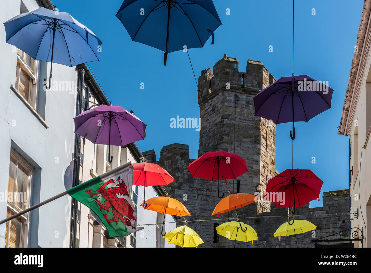 Caernarfon. Il Galles del Nord. Flying ombrelloni in arte di strada. Palace Street. Foto Stock