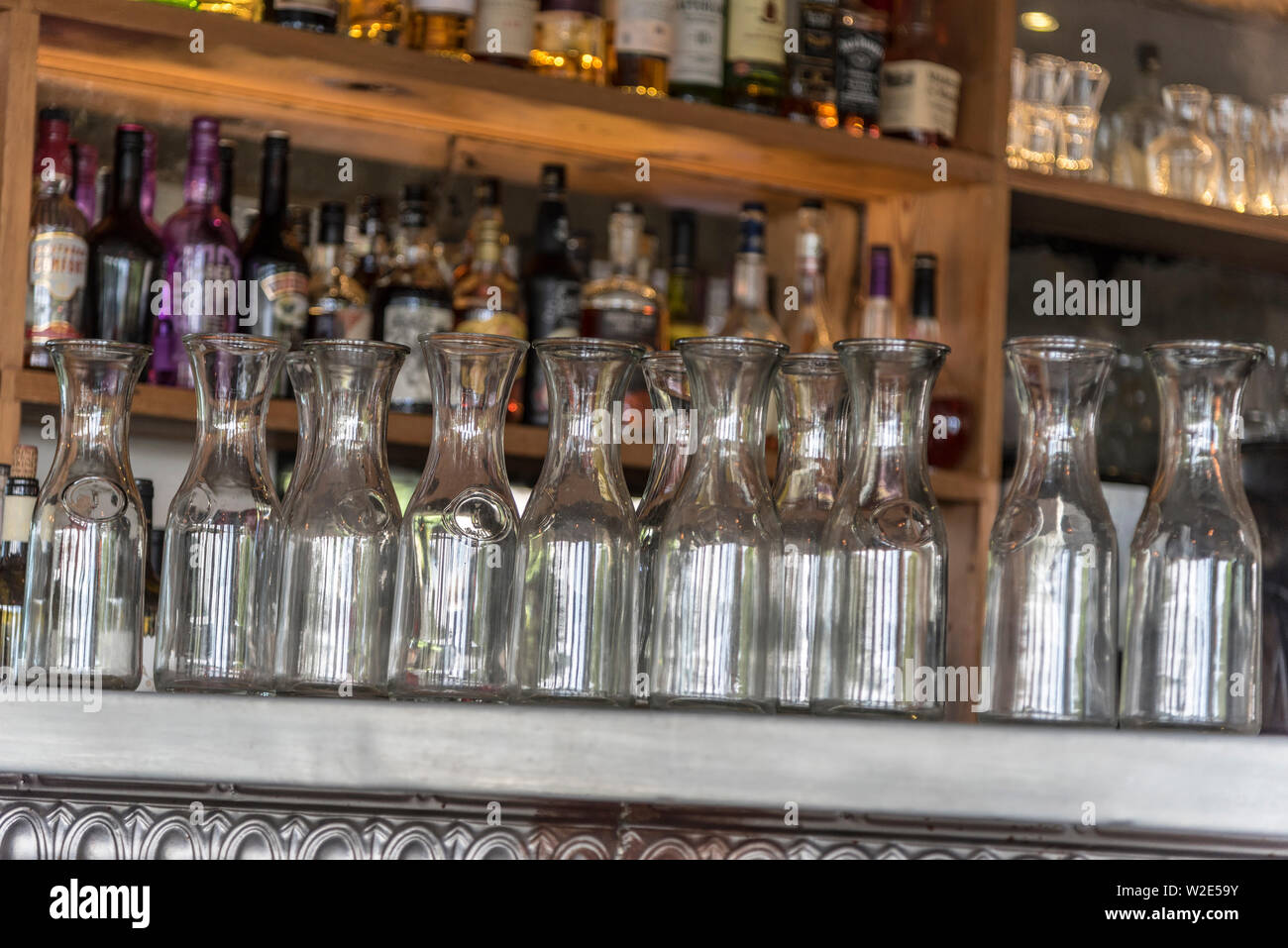 Svuotare il vino in caraffa su un banco di bar. Foto Stock Svuotare il vino in caraffa su un banco di bar. Foto Stock