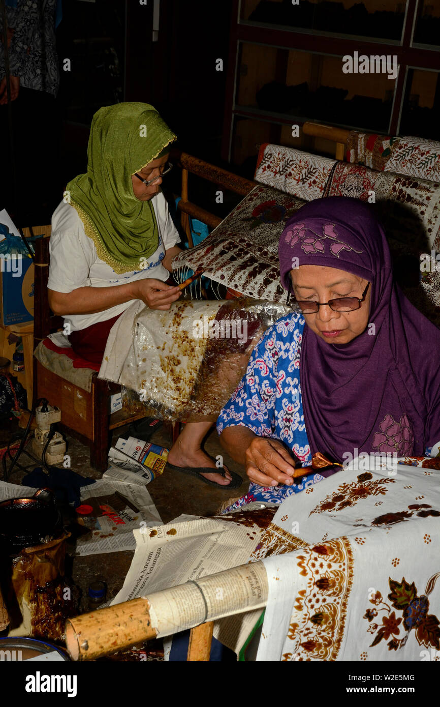 Yogyakarta, di Yogyakarta/Indonesia - 10 novembre 2015: le donne applicando modelli in cera su tessuti in una fabbrica Batik Foto Stock