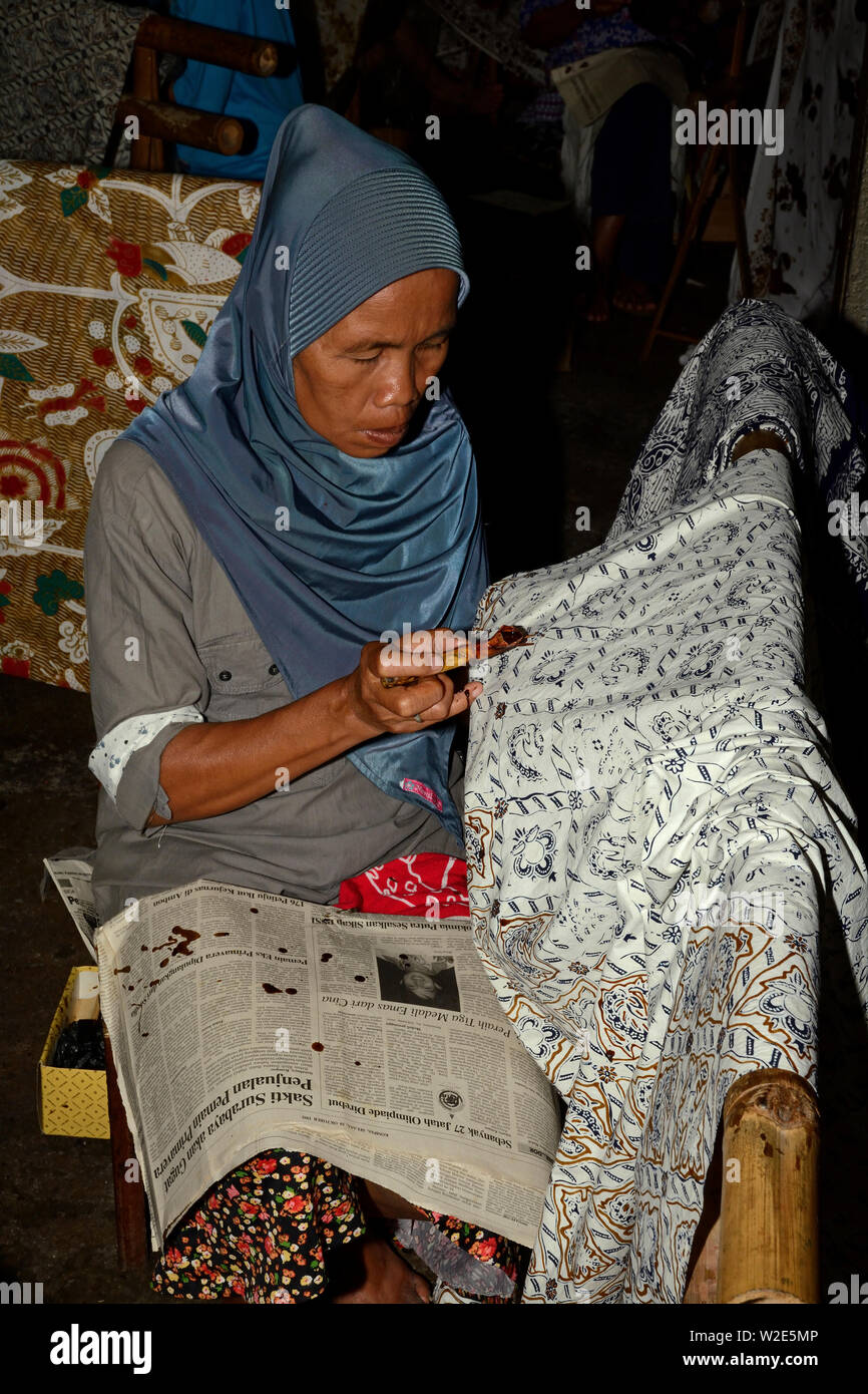 Yogyakarta, di Yogyakarta/INDONESIA - Novembre 10, 2015: una donna l'applicazione di modelli in cera su tessuti in una fabbrica Batik Foto Stock