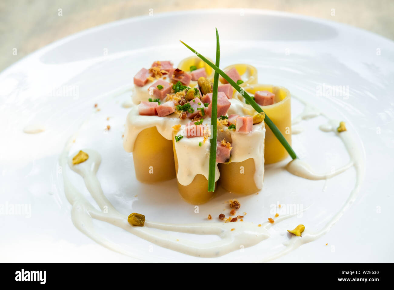 Paccheri fresco italiano la pasta tradizionale con la mortadella Bologna prosciutto cotto, formaggio, crema, i pistacchi,bellissima guarnire la placcatura d'arte chef professionale ammenda Foto Stock