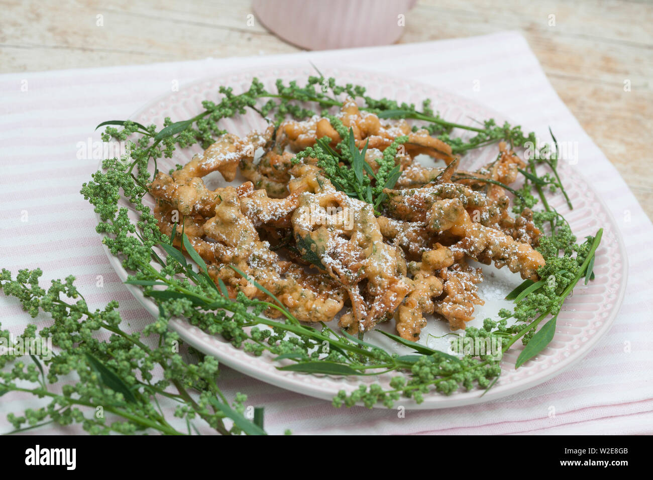 Gänsefuß-Küchle, Gänsefussküchle, Gänsefuss-Küchle, Gänsefuss-Pfannkuchen, Blüten und Blätter vom Weißen Gänsefuß werden in Pfannkuchenteig, Teig geta Foto Stock