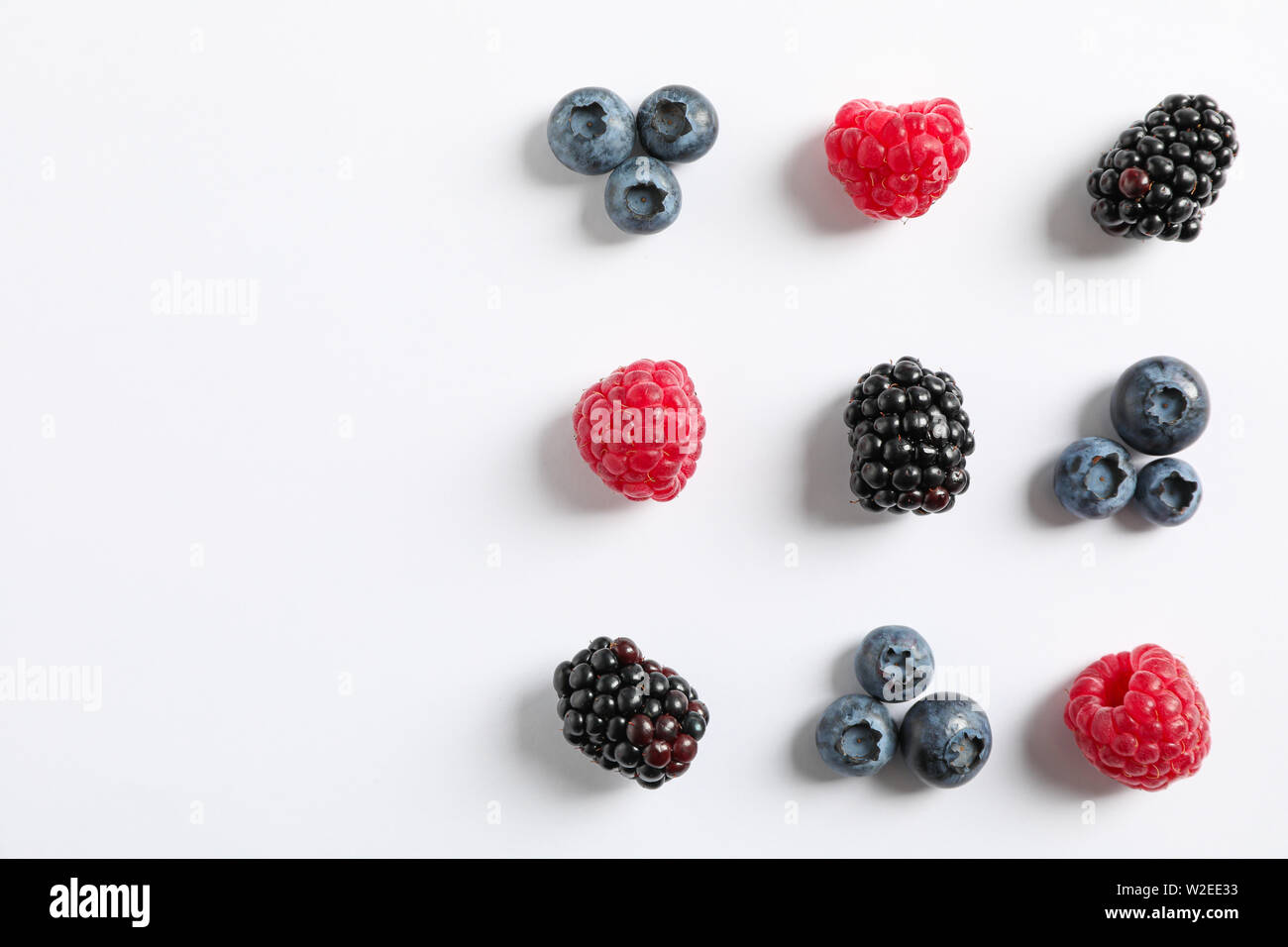 Piano di composizione dei laici con frutti di bosco su sfondo bianco, spazio per il testo Foto Stock
