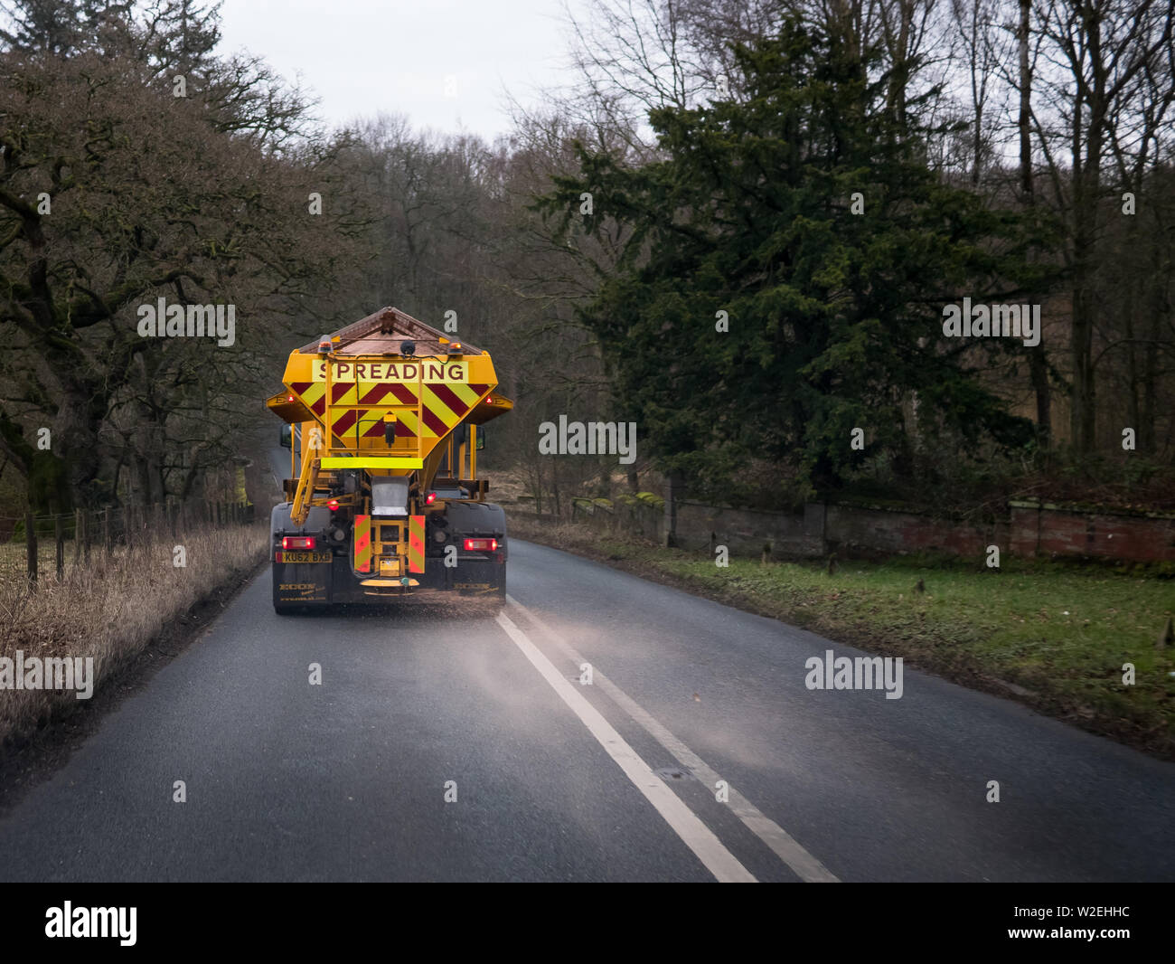 Immagine a colori di una strada macchina Gritting spargimento sale su strada nel Regno Unito Foto Stock