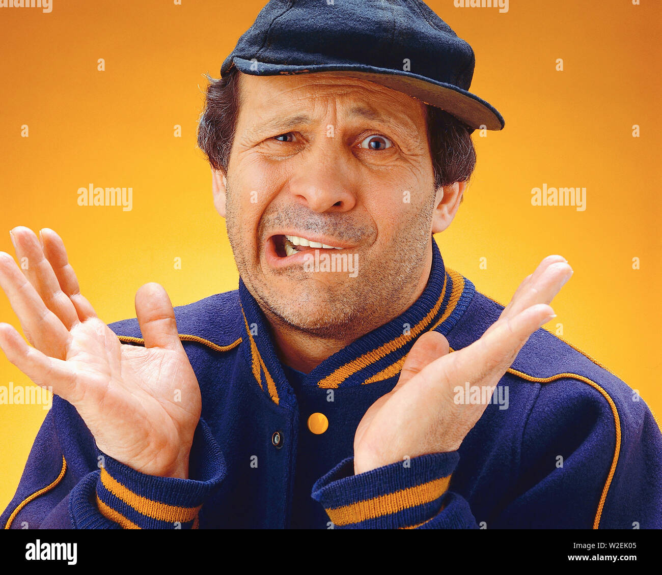 Gli uomini che indossa un cappello da baseball con le mani alzate molto preoccupato Foto Stock