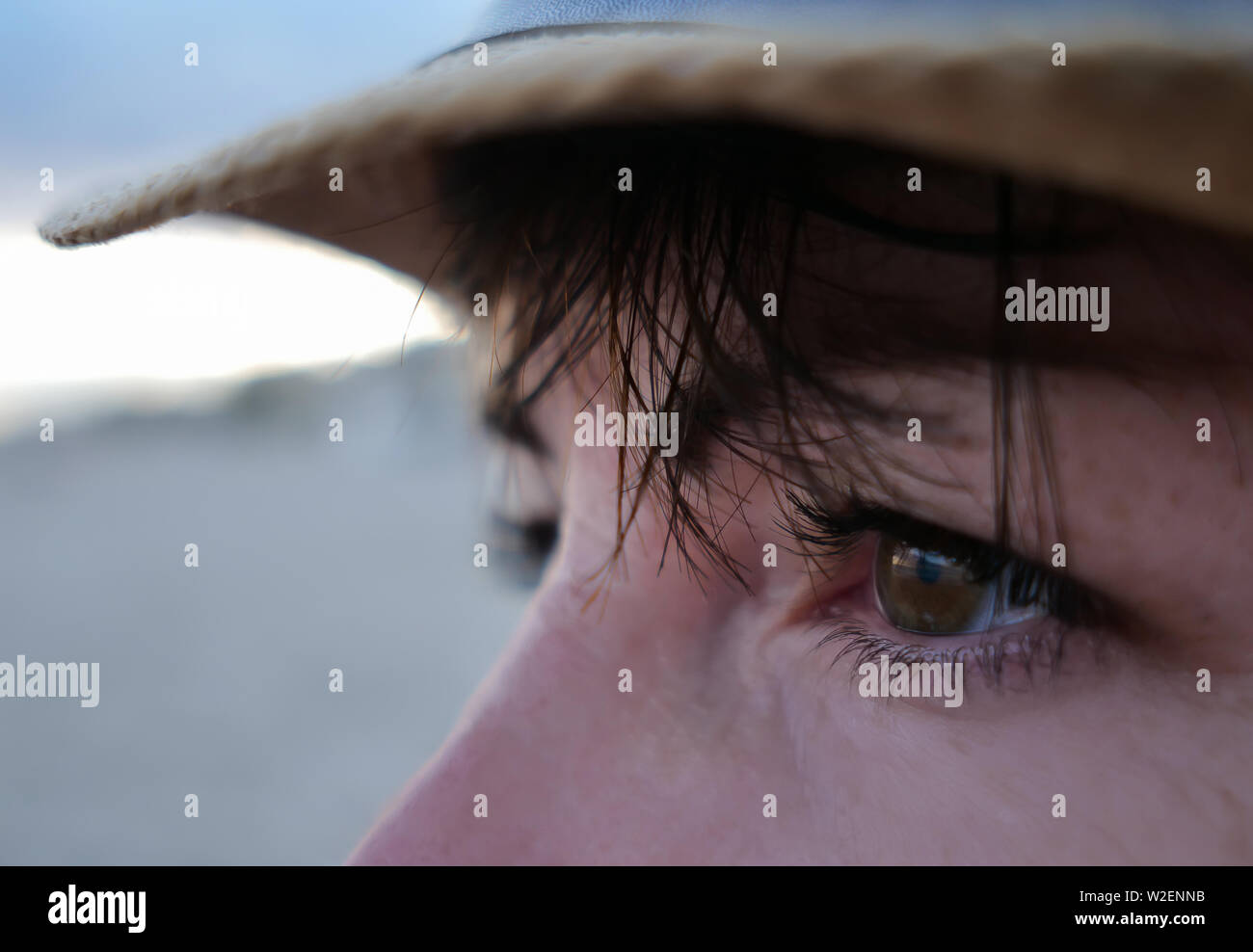 Uno sguardo nella direzione di una bruna con occhi marroni con un bang in un cappello di paglia Foto Stock