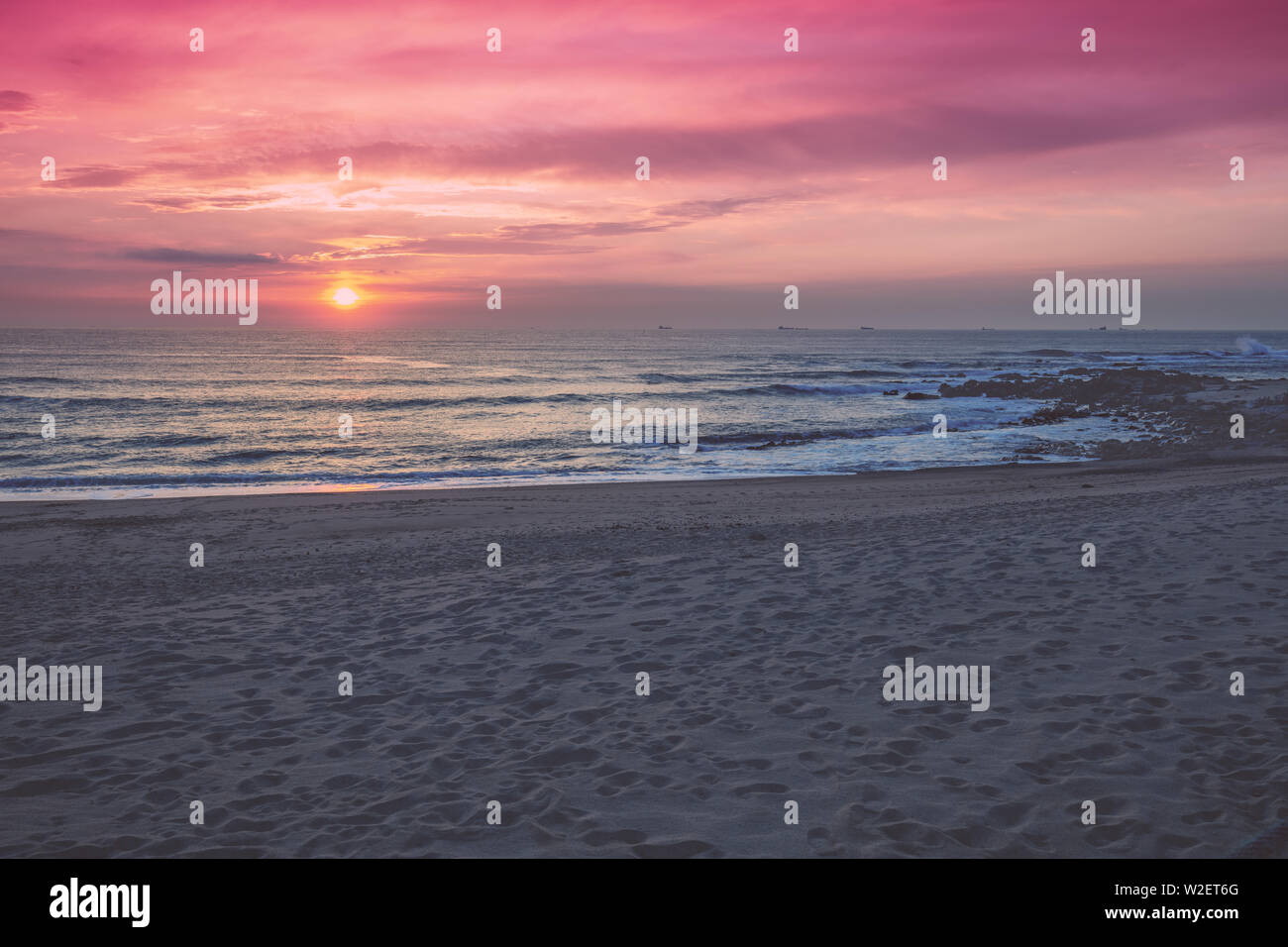 Tramonto sull'oceano. Spiaggia di sabbia al tramonto. Bella Riva del mare in serata. Porto, Portogallo, Europa Foto Stock