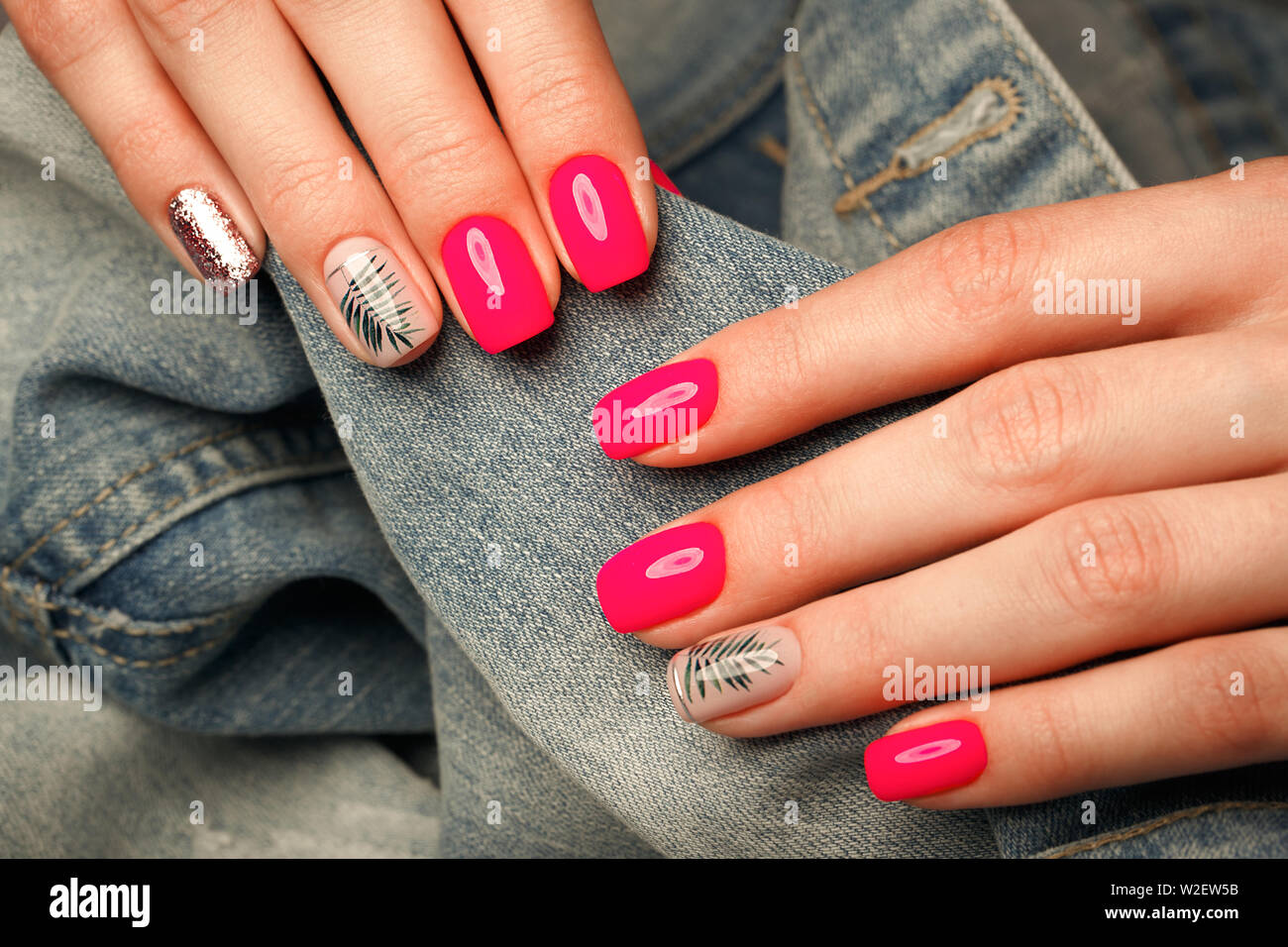 Neon luminoso manicure su mani femminili sullo sfondo di jeans. Il design  delle unghie. Bellezza Le mani Foto stock - Alamy
