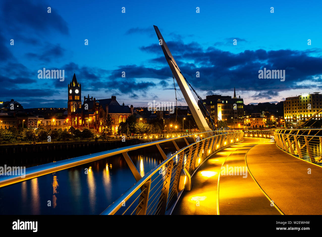 Derry, Irlanda del Nord. Illuminato il ponte di pace in Derry Londonderry in Irlanda del Nord con il centro della città in background. Notte cielo nuvoloso, refle Foto Stock