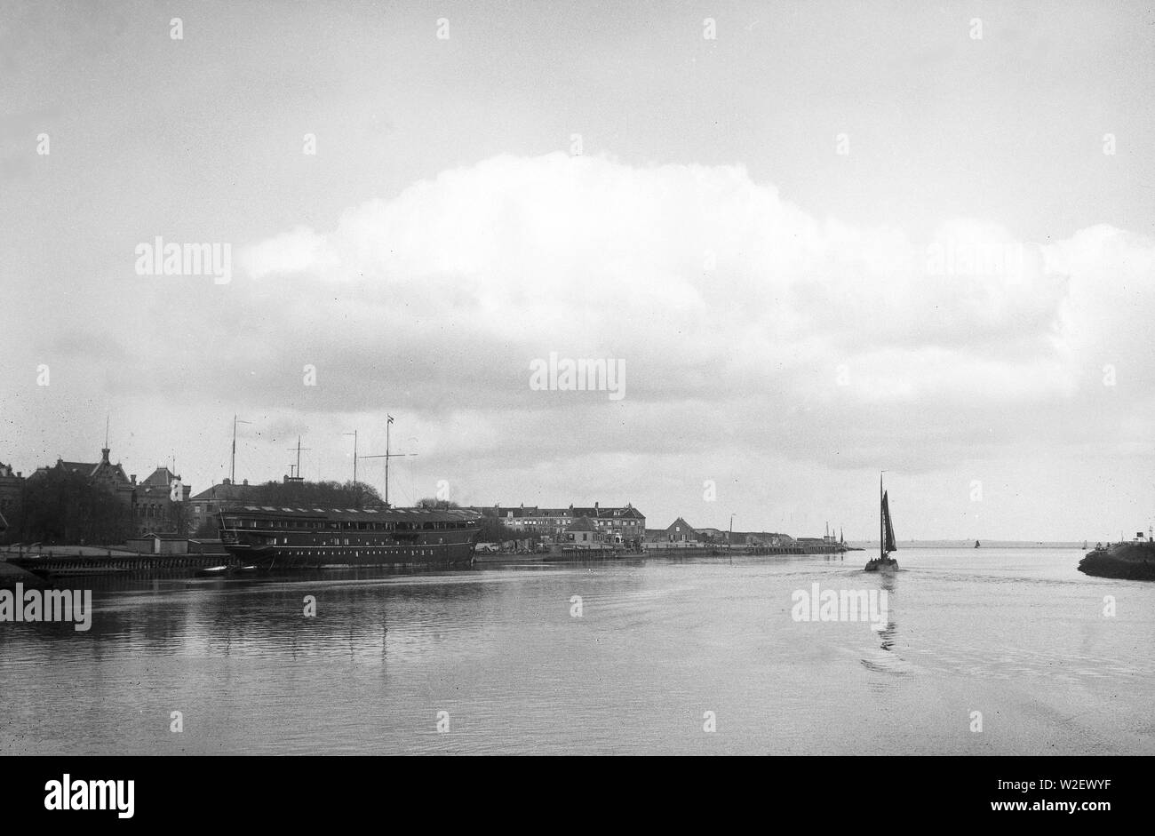 Una barca da pesca lascia il porto con la nave di guardia sulla sinistra e Fort Harssens sulla destra Foto Stock