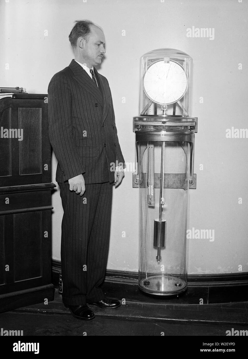 Uomo con un Riefler orologio a pendolo, lo standard principale per intervallo di tempo misure dal 1904 al 1929 ca. 1931 Foto Stock