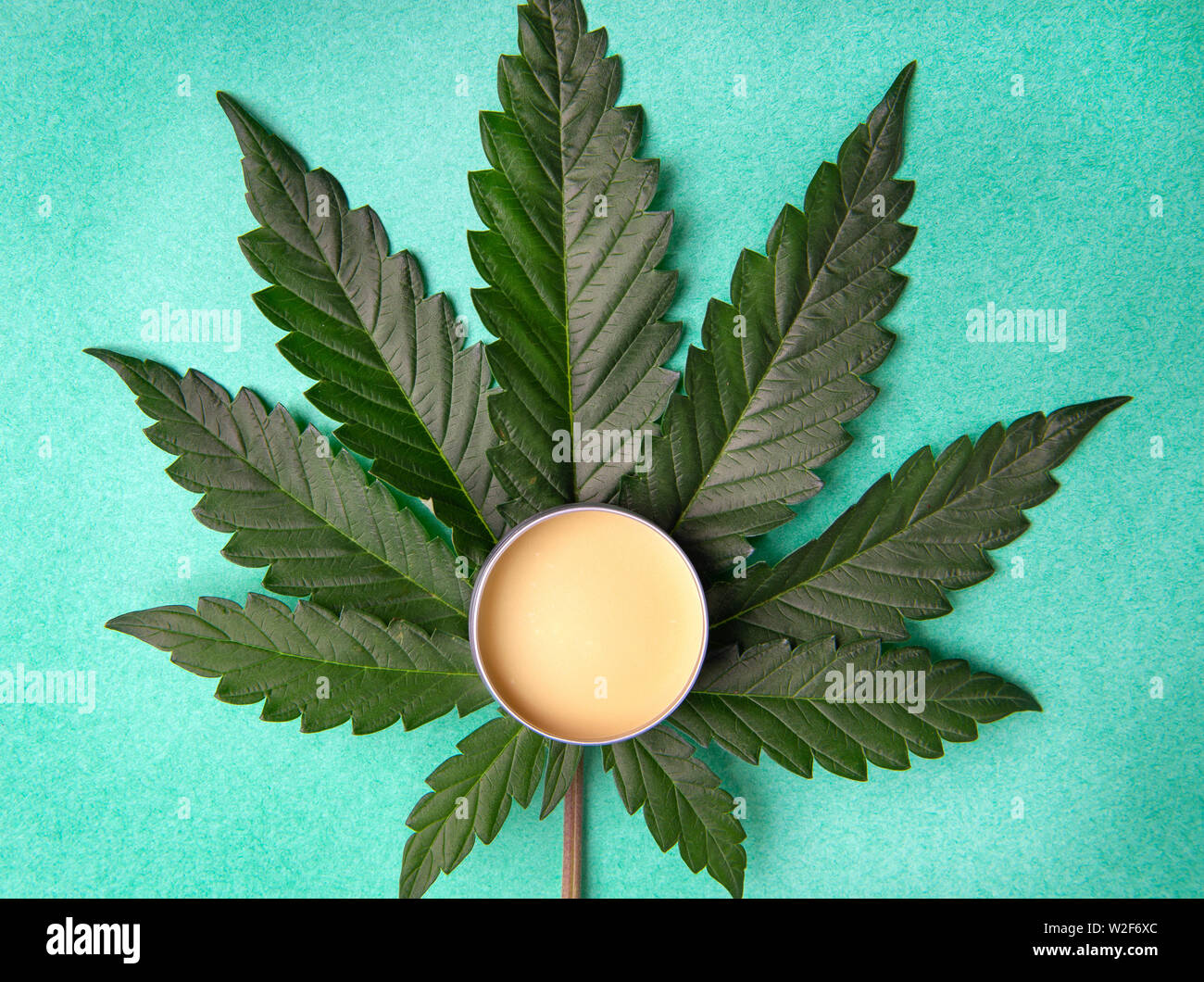 La Cannabis salve con la canapa e il CBD di olio e foglie di marijuana su sfondo verde Foto Stock