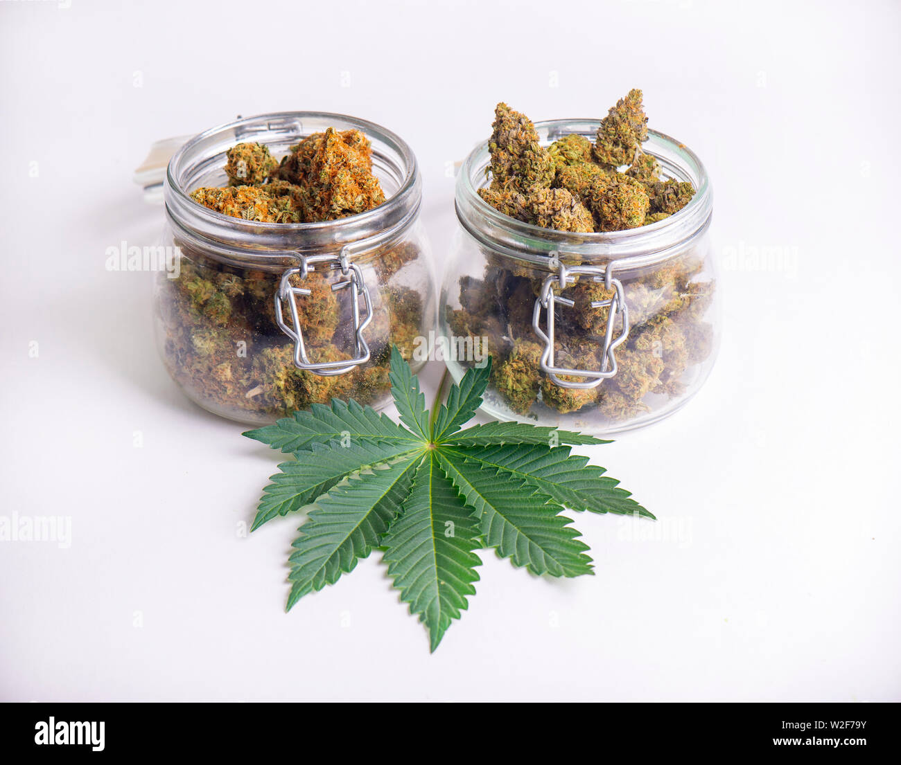 Dettaglio delle gemme di cannabis su chiari vasetti di vetro isolato su bianco - la marijuana medica del dispensario del concetto Foto Stock