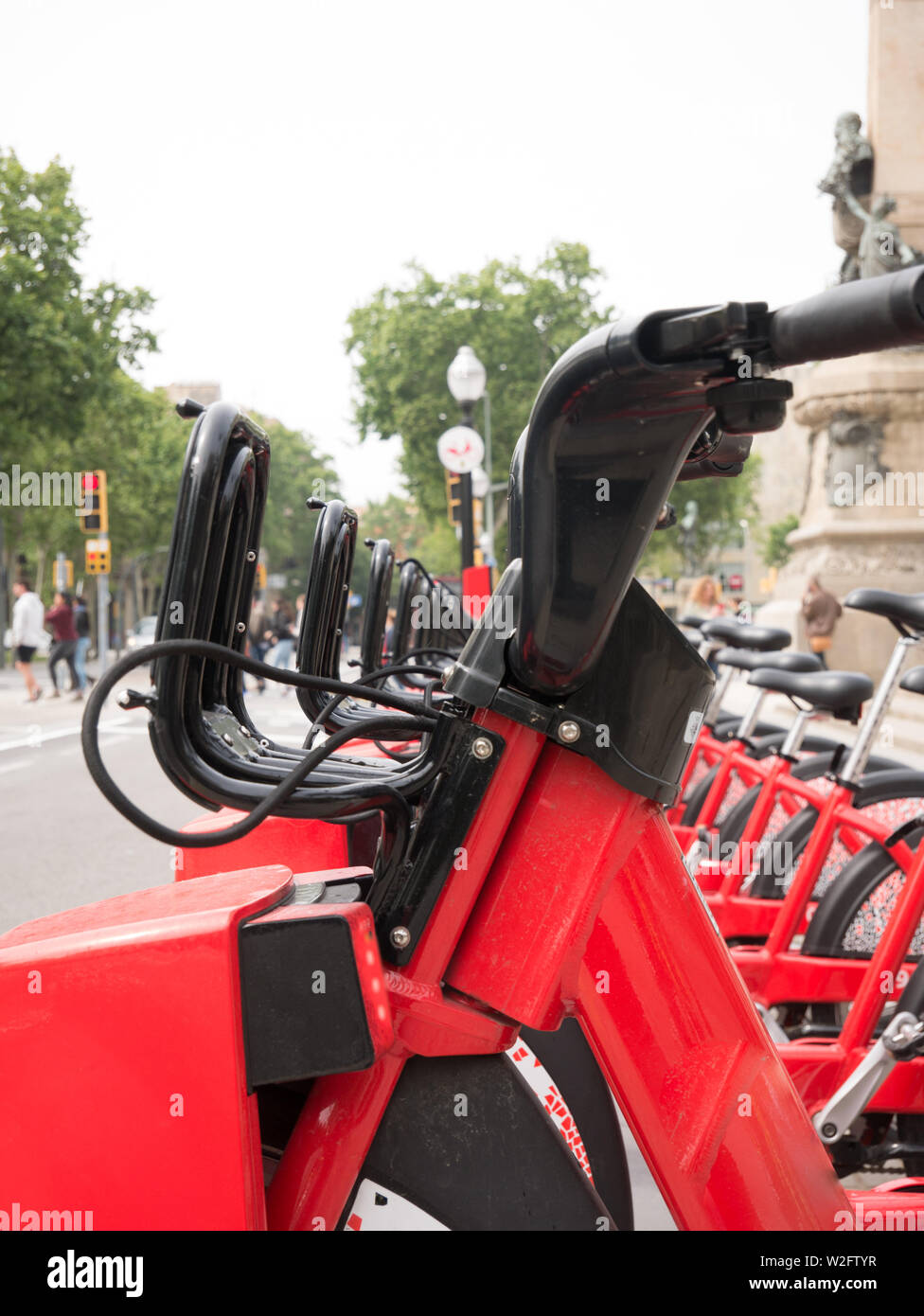 Fila di biciclette rosse in un portabiciclette, disponibili per il noleggio per le strade di Barcellona Foto Stock