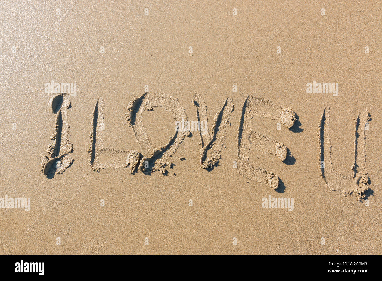La parola "I Love U' scritto a mano su una spiaggia. Foto Stock