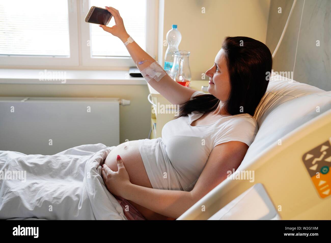 Rischio di gravidanza, donna incinta in ospedale e facendo Selfie, Karlovy Vary, Repubblica Ceca Foto Stock