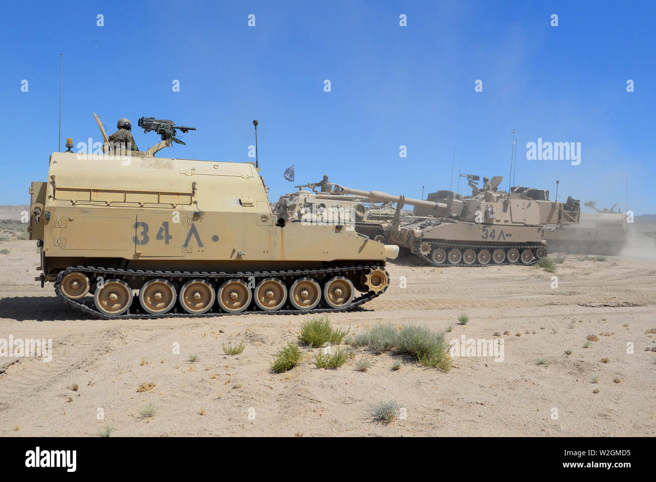 North Carolina National Guard trentesimo Armored Brigade Combat Team M109A6 Paladin semoventi obici, un M992 Campo munizioni di artiglieria veicolo di supporto e una M88A1 Hercules Recupero veicolo in posizione sulla pistola linea presso il Centro Nazionale di Allenamento (NTC), Fort Irwin, California, 4 luglio 2019. Il ABCT militari impegnati per il funzionamento Hickory pungiglione al NTC per le migliori e più attuali Combat training disponibile negli Stati Uniti Esercito la loro preparazione per la distribuzione all'estero più tardi questo autunno. (U.S. Esercito nazionale Guard Foto di Sgt. 1. Classe Robert Jordan, North Carolina Guardia Nazionale Pubblico affa Foto Stock