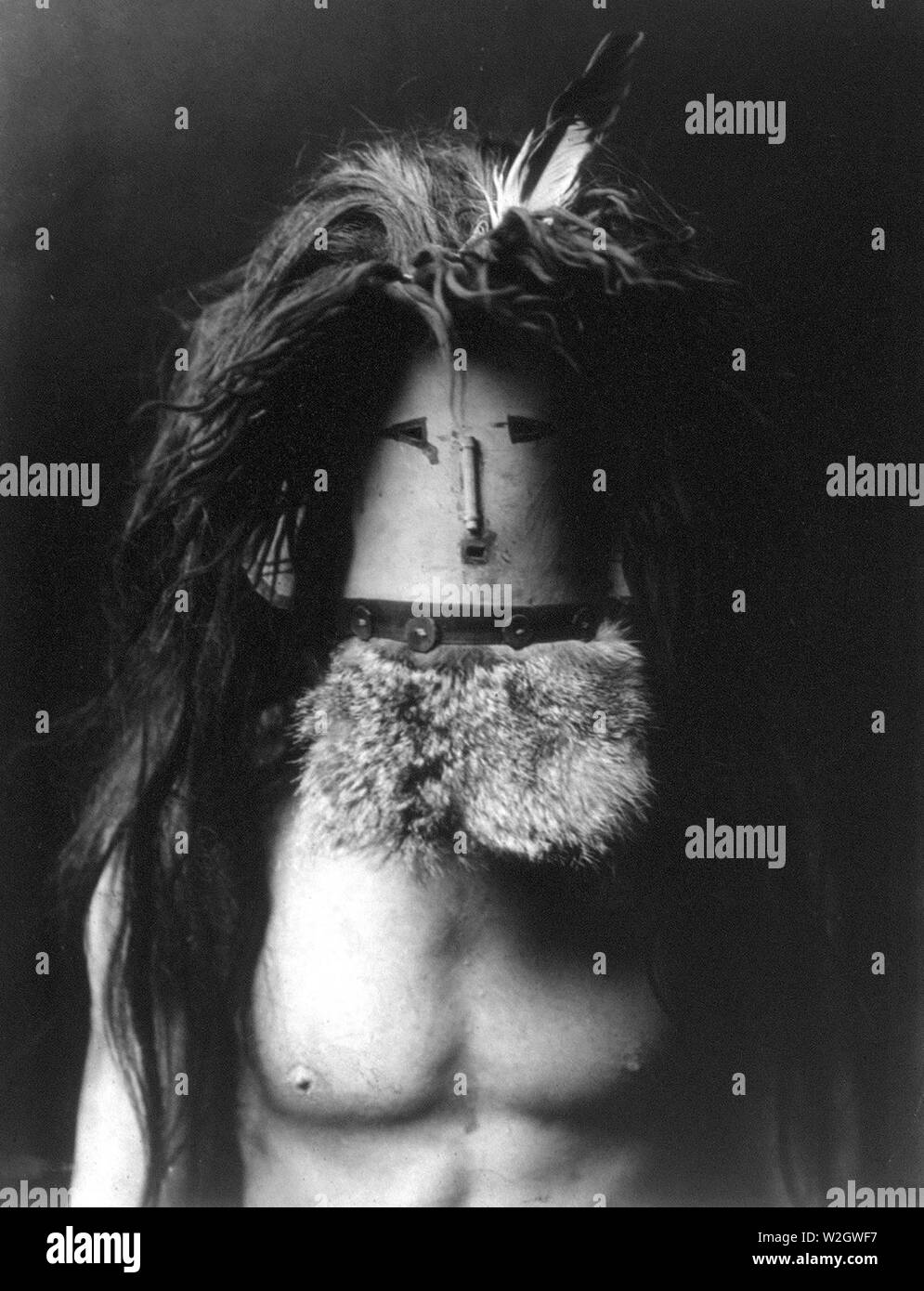 Edward S. Curtis nativi indiani americani - Barechested Navajo uomo che indossa la maschera di Haschebaad, un benevolo divinità femminile ca. 1905 Foto Stock