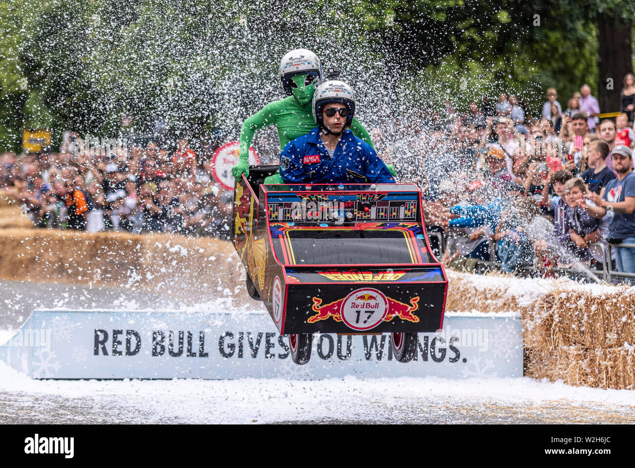 Il Difensore del team in lizza nella Red Bull Soapbox Race 2019 a Alexandra Park, London, Regno Unito. Space Invaders gioco saltando su rampa con persone Foto Stock
