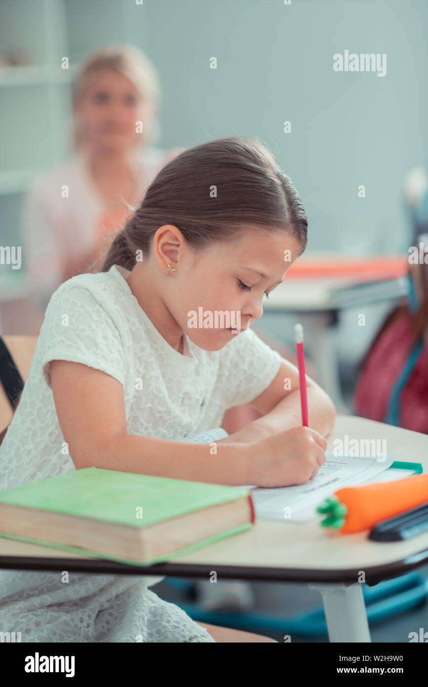 Schoolgirl lavorando duro per la sua prova di matematica. Foto Stock