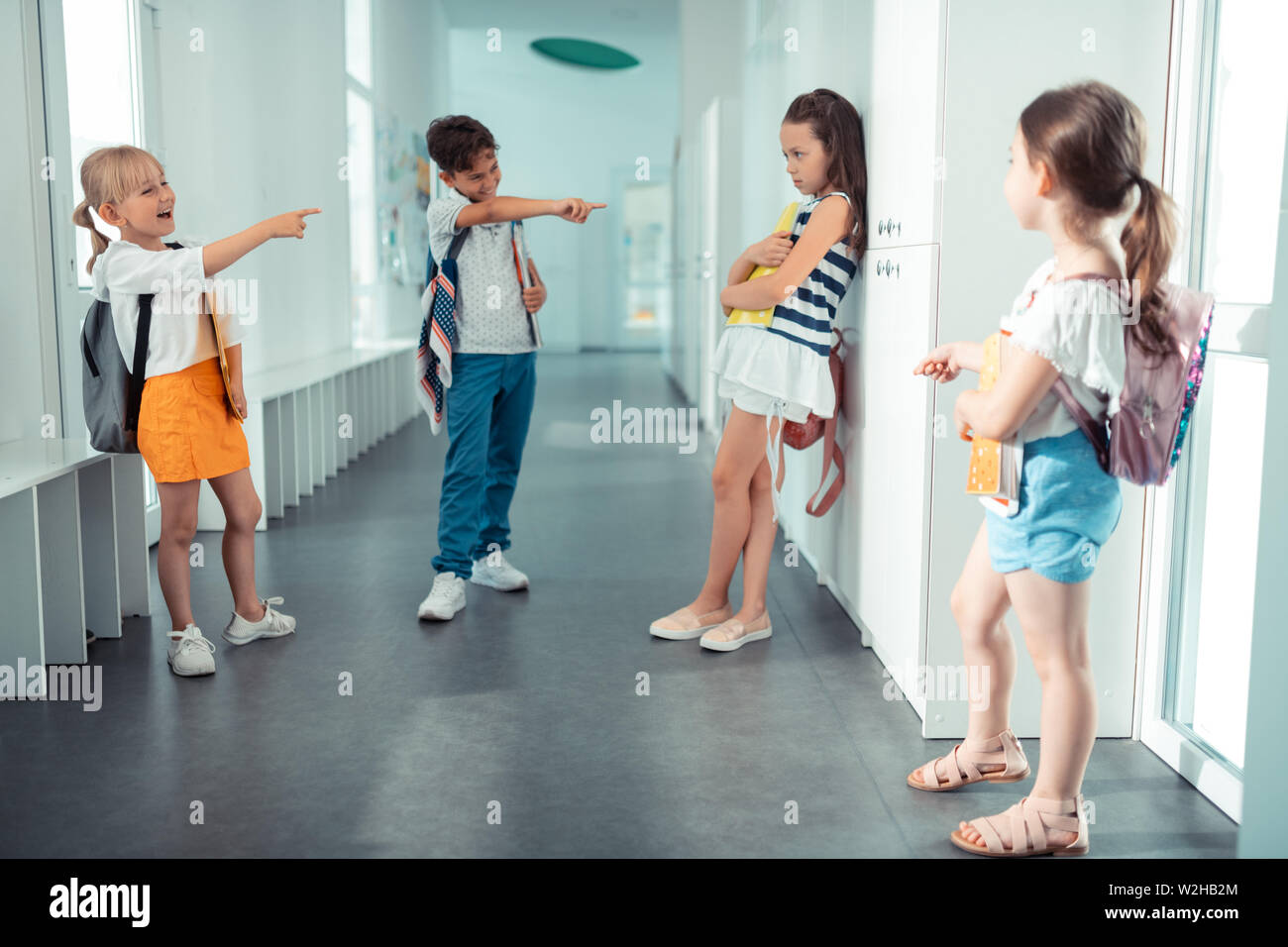 Rude bambini con cattivo comportamento bullismo il loro compagno di classe Foto Stock