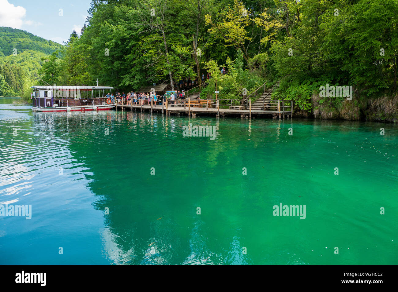 Traghetto ormeggiato al molo presso il colore azzurro cristallino puro e il Lago Kozjak, il Parco Nazionale dei Laghi di Plitvice, Croazia Foto Stock