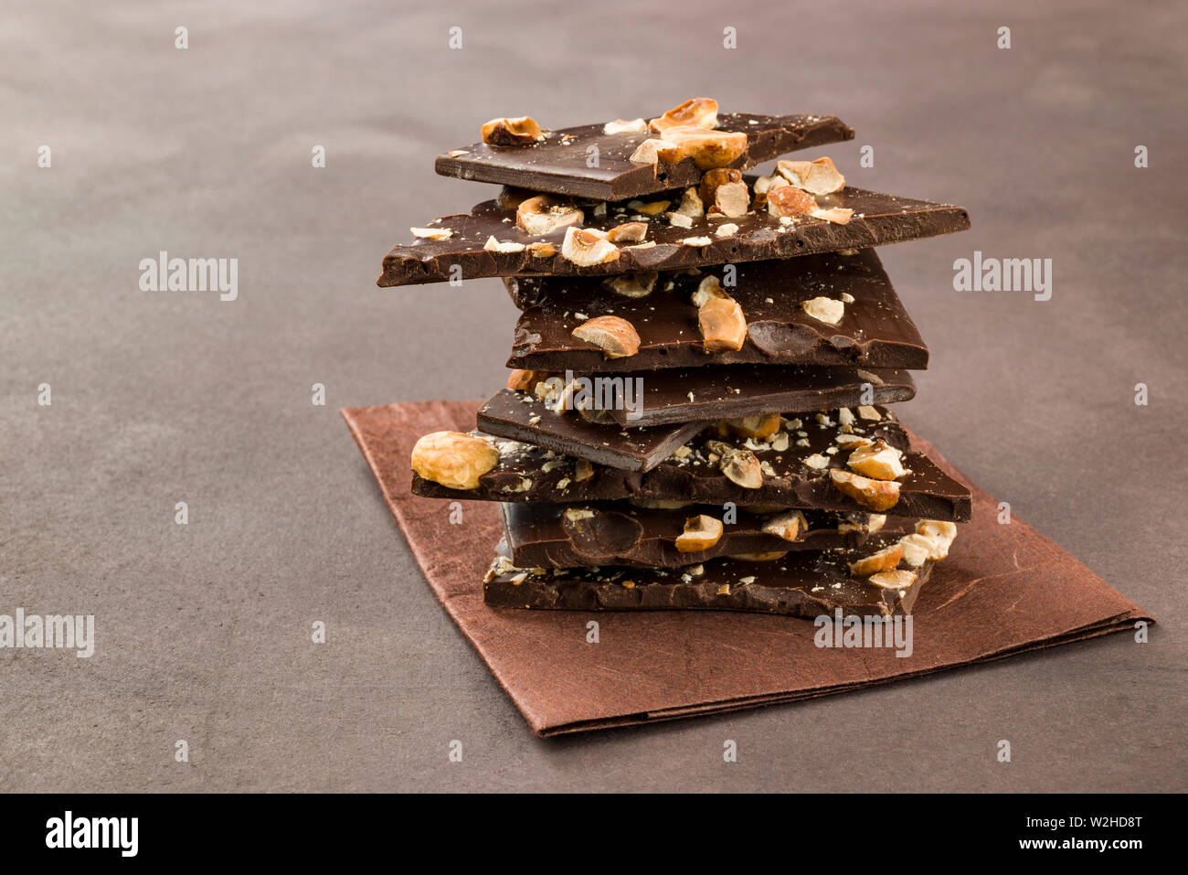 Nocciola scuro pezzi di cioccolato su sfondo marrone Foto Stock Nocciola scuro pezzi di cioccolato su sfondo marrone Foto Stock