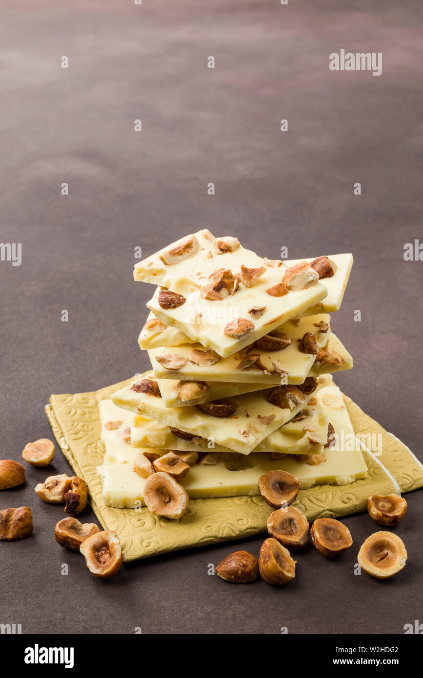 Nocciola e Cioccolato bianco pezzi su sfondo marrone Foto Stock Nocciola e Cioccolato bianco pezzi su sfondo marrone Foto Stock