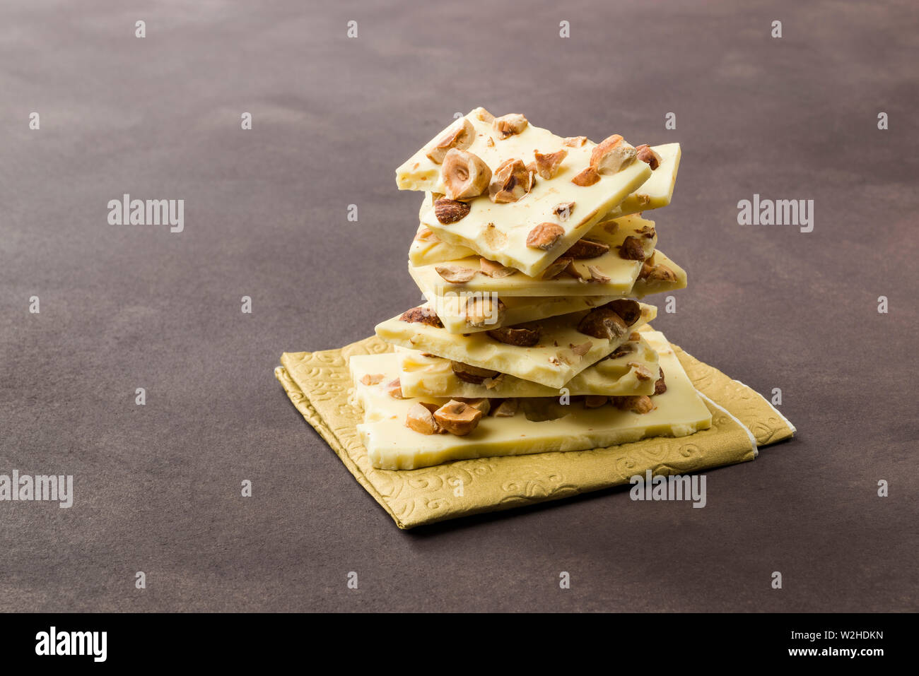 Nocciola e Cioccolato bianco pezzi su sfondo marrone Foto Stock Nocciola e Cioccolato bianco pezzi su sfondo marrone Foto Stock