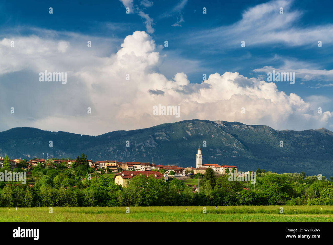 Bellissimo paesaggio nella Valle del Vipava, Slovenia. Piccola città con la torre campanaria e la cresta di montagna Foto Stock