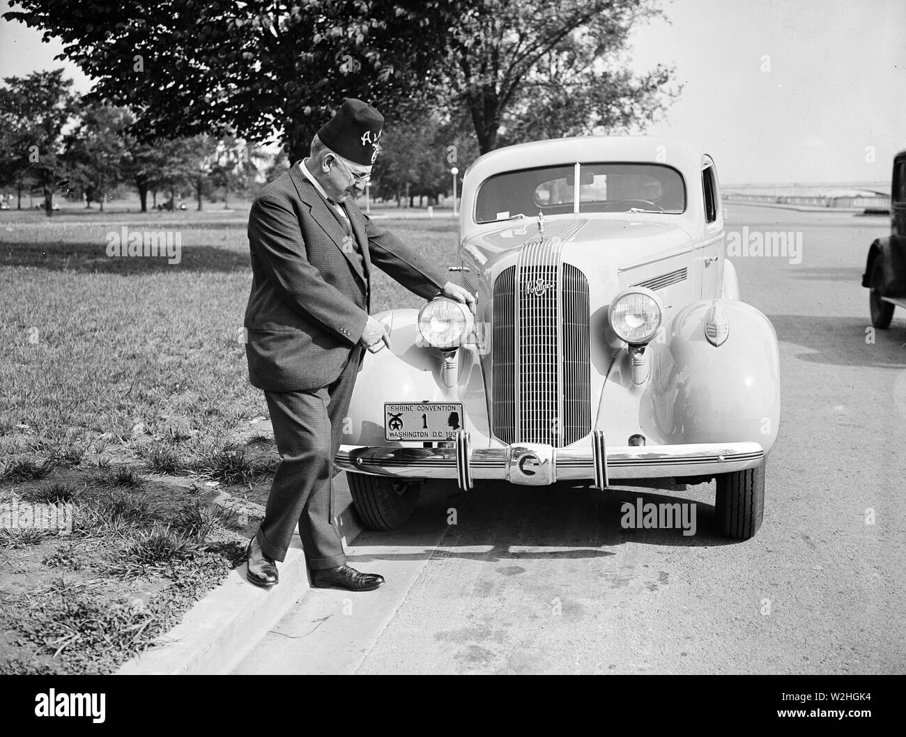 Shriner L.P. Steuart standing in auto, puntando a personalizzato piastra licenza ca. 1935 Foto Stock