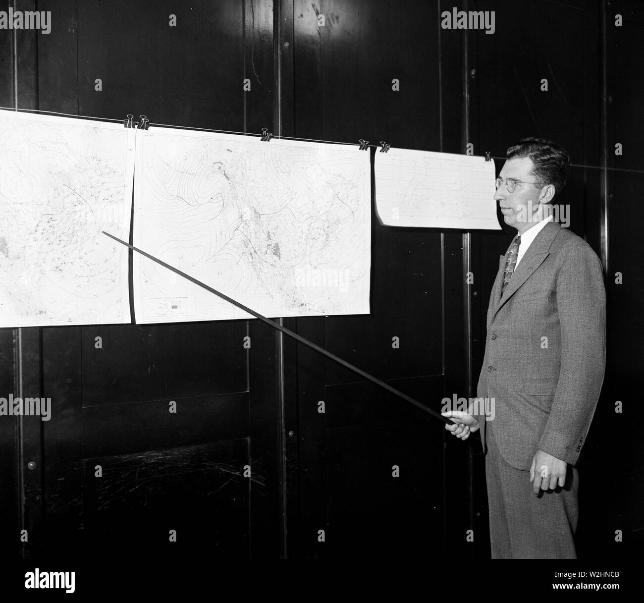 Uomo che puntano a mappe meteorologiche ca. 1936 Foto Stock